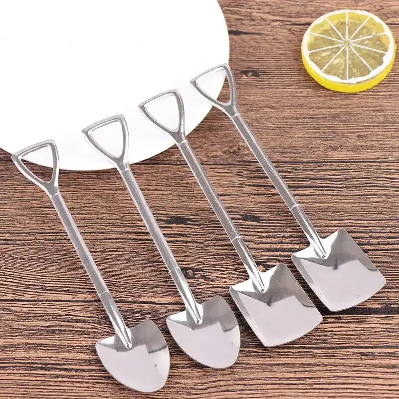 Set of four shiny stainless steel teaspoons shaped as miniature shovels with triangular handles on wood surface