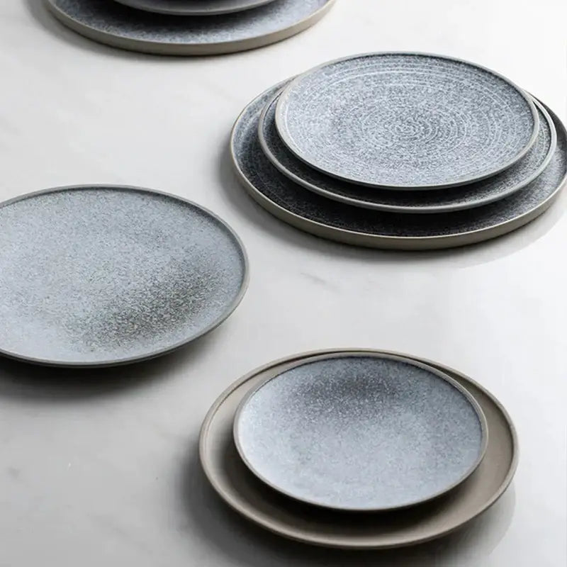 Set of matte gray decorbites ceramic dinner plates with speckled texture and concentric patterns in a dinner plate set