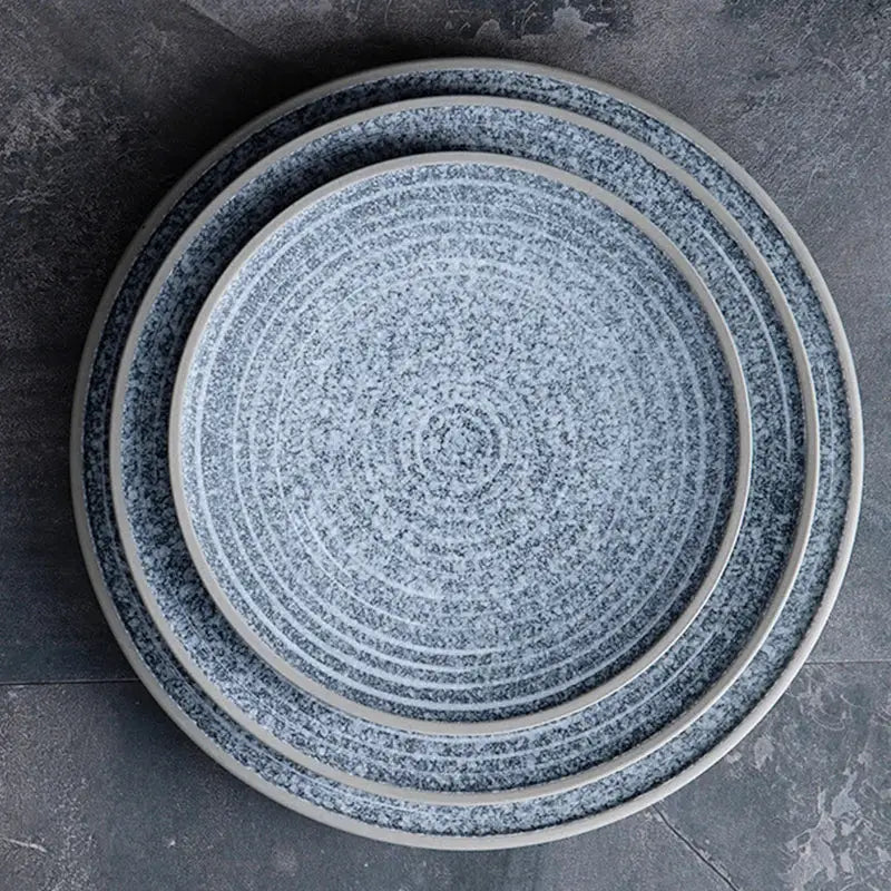 Set of three decorbites ceramic dinner plates in speckled blue and white with concentric ridges and smooth rims