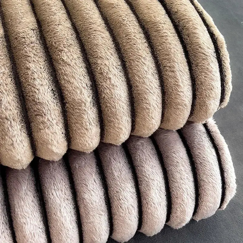 Beige plush corduroy fabric with fuzzy texture and ridged stripes on striped gray and black dark faux rabbit plush blanket throw