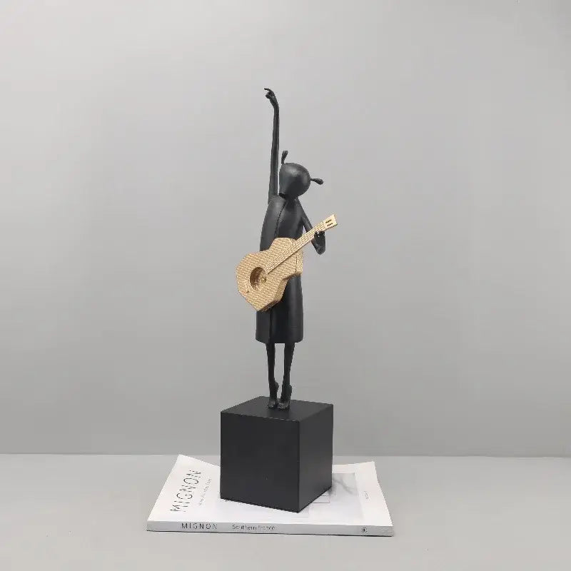 Stylized black and gold guitarist resin figure standing on a black base ideal for decorbites guitarist resin decor