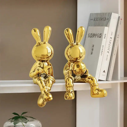 Stylized gold ceramic rabbit sculpture set featuring two glossy reflective rabbit sculptures for living room decor