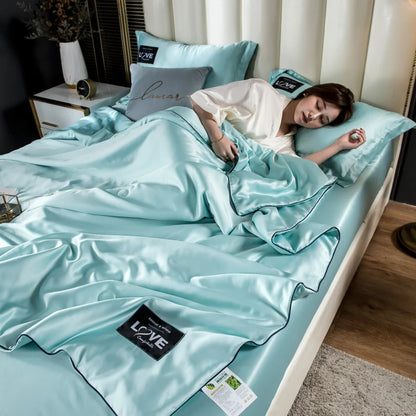 A soft light blue satin summer mulberry silk comforter duvet insert with black piping and branded label