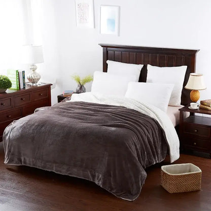 Plush dark gray and white sherpa throw blanket draped over bed featuring decorbites cozy lambswool flannel texture