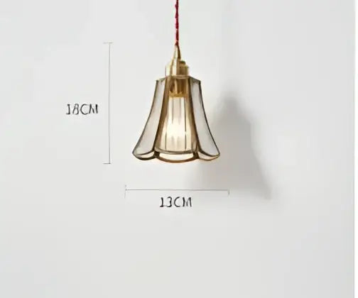 Teal blue glass pendant light with brass hardware featuring a brass-toned fluted glass shade and exposed filament bulb