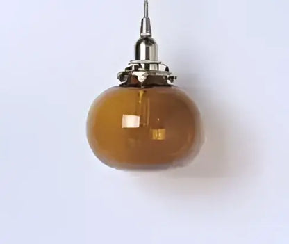 Amber-colored glass pendant light with metallic fixture complementing decorbites blue glass pendant lights for dining room decor