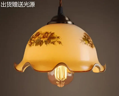 Teal blue glass pendant light with brass hardware featuring warm-toned floral decals and vintage bulb for dining room decorbites blue glass pendant lights