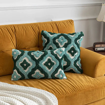 Two plush teal and dark green decorbites boho tufted pillow covers with geometric pattern on mustard velvet sofa