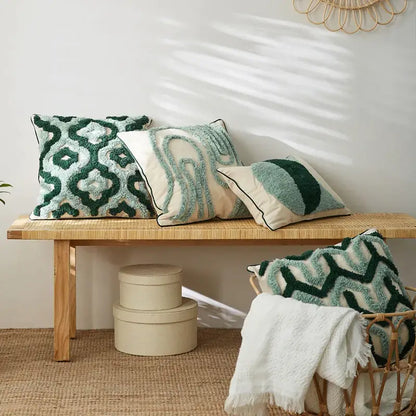Three textured teal and dark green cushion cases with decorbites geometric embroidery tassel on woven bench decor