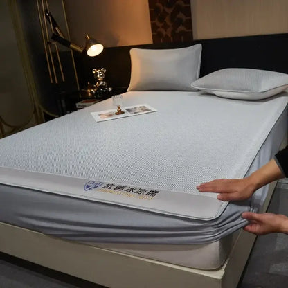 Gray textured mattress pad with antibacterial embroidery and reinforced edge complements silky soft fitted sheet set