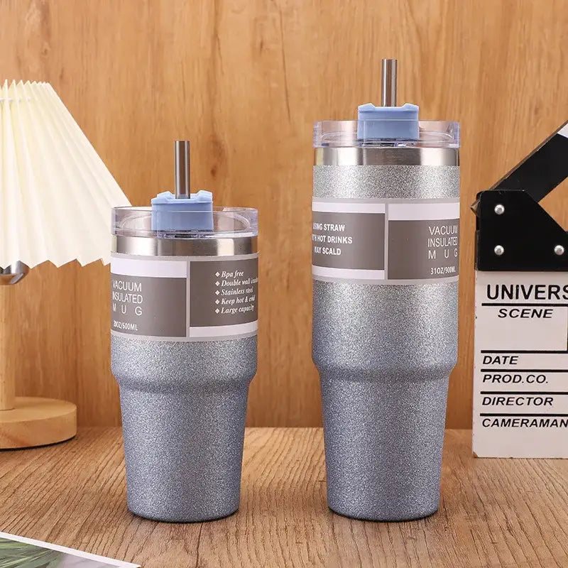 Two silver glitter finish decorbites coffee cup thermos mugs with blue straw lids and stainless steel straws in 30oz and 20oz sizes