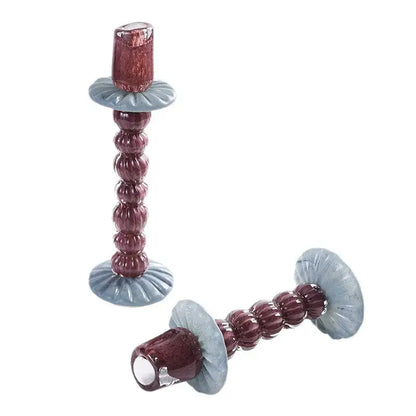A pair of textured burgundy and light blue geometric glass candlestick holders with bead-like segments for dining room decorbites