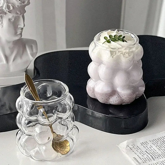Clear glass drinking set with bubbly textured surface and gold spoon for elegant dining room use