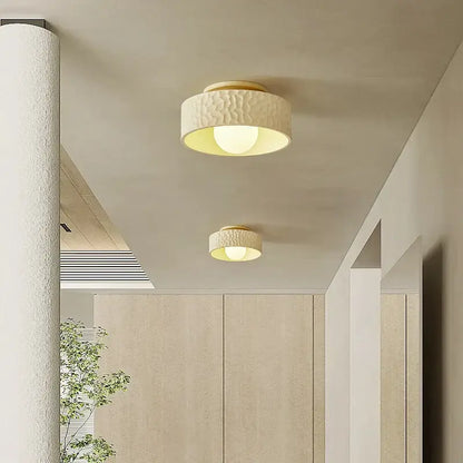 Cream ceiling light with textured surface and gold-toned metallic trim providing warm diffused glow for living room decorbites cream ceiling