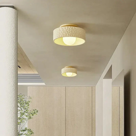 Cream ceiling light with textured surface and gold-toned metallic trim providing warm diffused glow for living room decorbites cream ceiling