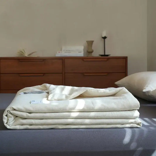 A neatly folded cream-colored linen cotton summer throw with subtle textured weave for decorbites linen cotton decor