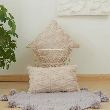 Beige textured throw pillows with geometric diamond embroidery living cushion cover displayed with matching pom-pom rug