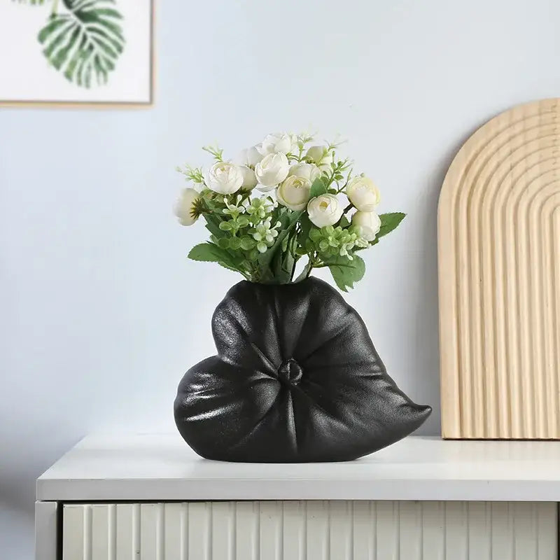 Black leaf-shaped ceramic fluffy heart vase with glossy finish holding white artificial flowers for living room decorbites decor