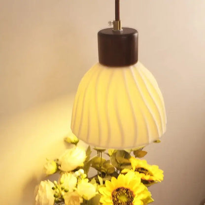 Warm-toned ribbed glass wall light fixture with dark wood top designed for dining room use
