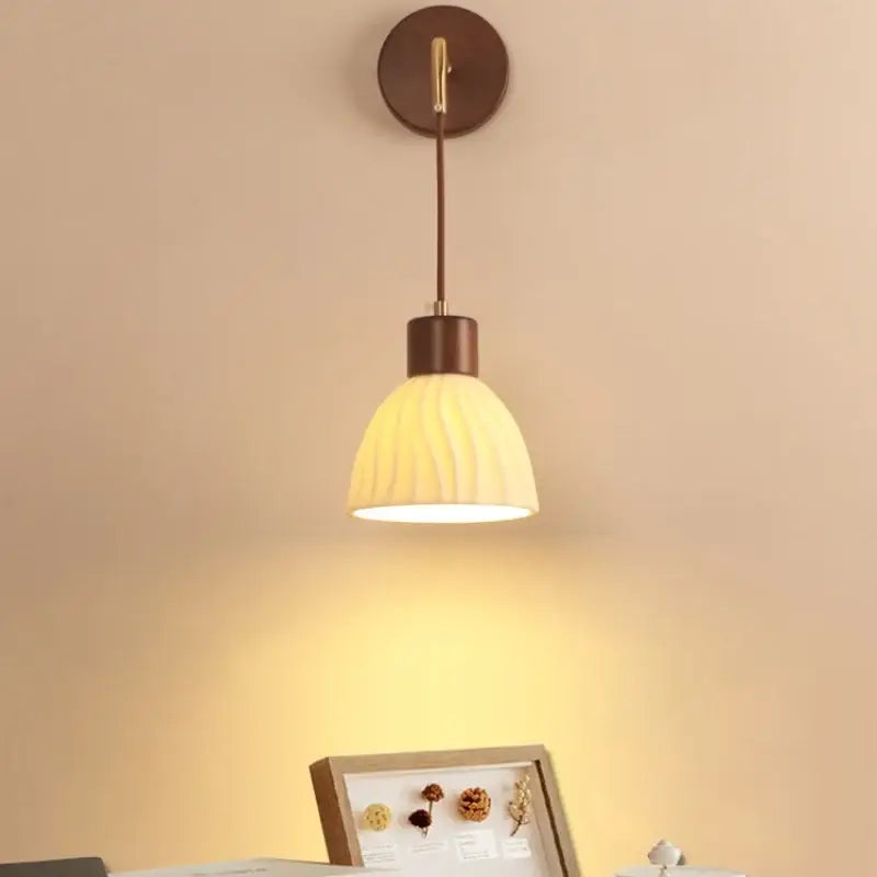Warm-toned wall light fixture with textured cream glass shade and dark bronze metal accents for dining room use