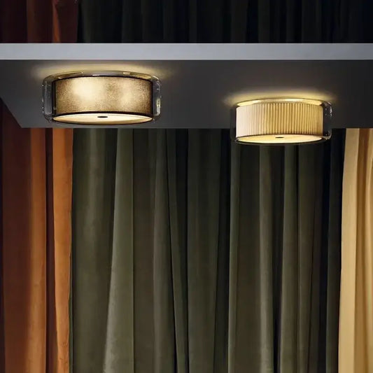 Two circular ceiling lights with a textured gold shade and pleated off-white glass shade for bedroom use