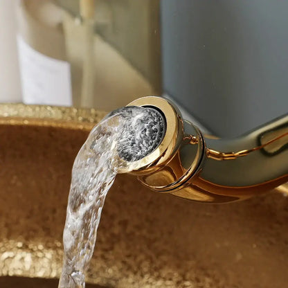 Gold-toned faucet pouring clear water into textured decorbites golden ceramic basin set for modern golden ceramic bathroom decor