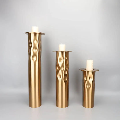 Set of three decorbites golden metal candlestick holders with textured wavy surface for dining room decor