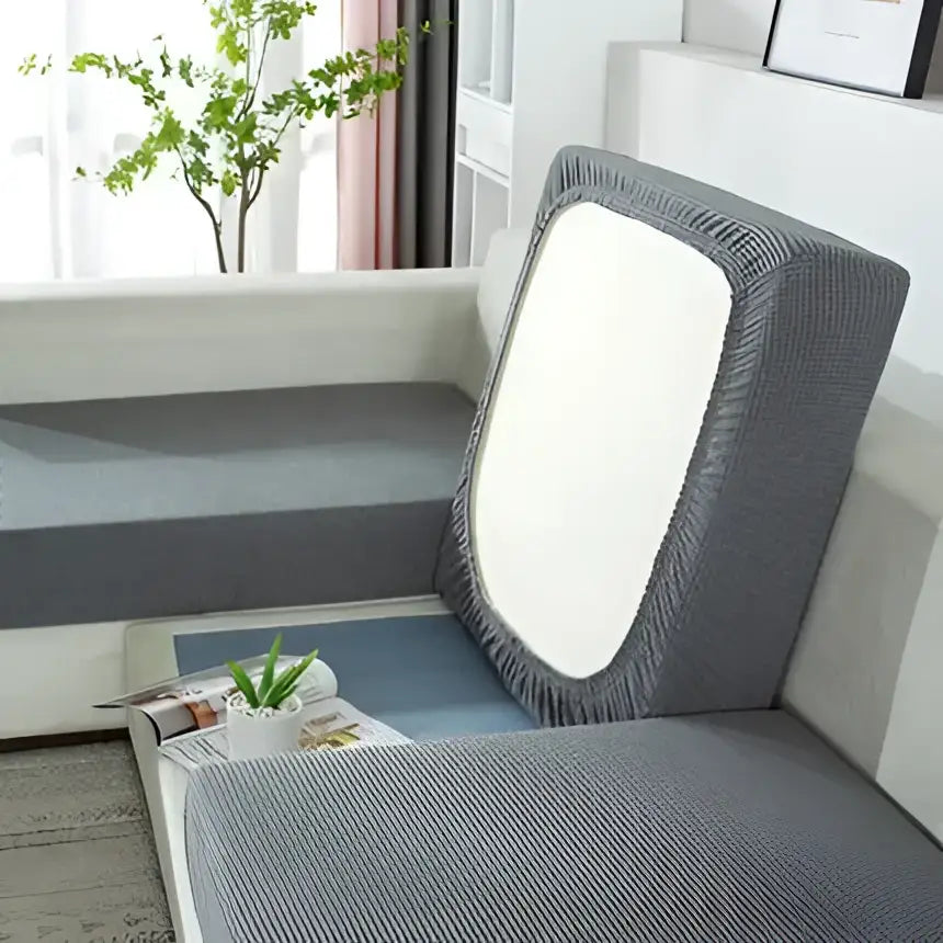 Gray textured fabric sofa cover with elasticized edges and a white central panel for living room furniture protection