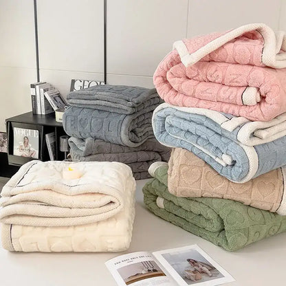 Stacks of textured green and cream cozy lamb wool blankets with quilted heart pattern for decorbites cozy lamb decor