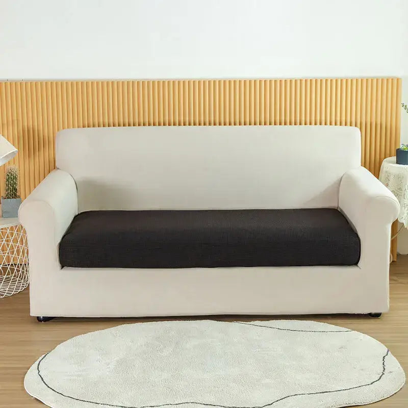 Cream-colored stretch sofa cover with black textured seat cushion for living room slipcover use