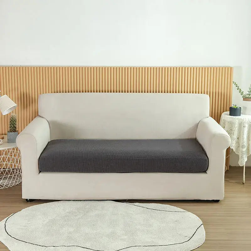Cream-colored stretchy sofa cover with dark gray textured seat cushion for living room slipcover use