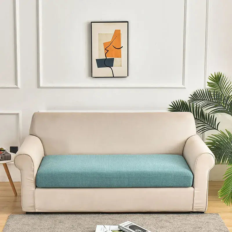 Beige sofa with teal textured cushion and green waterproof elastic sofa cover for living room slipcover use