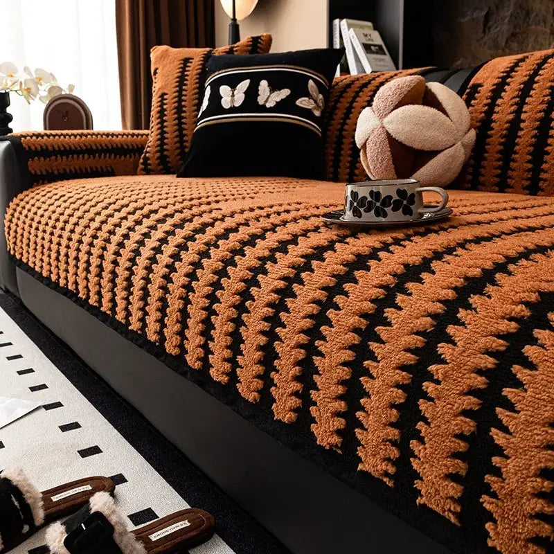 Textured olive and black striped knitted sofa cover with warm orange and black plush knit for living room slipcover