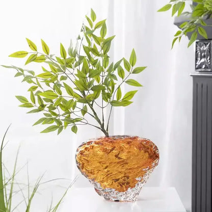 Heart-shaped glass colored vase with swirling amber and gold interior and textured silver base for living room decor