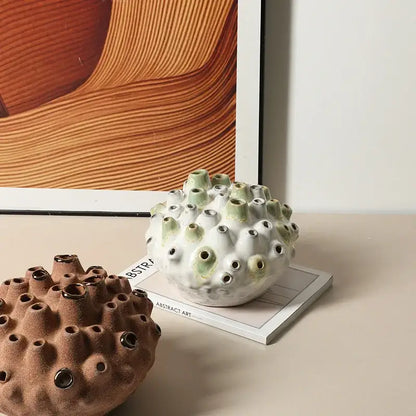 Textured white and green coral ball ceramic vase with green-tipped protrusions and black circular openings for decorbites coral ball decor
