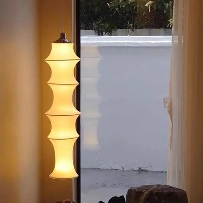 Warm-toned tiered floor lamp with decorbites cream silk shade and metallic top for soft living room lighting