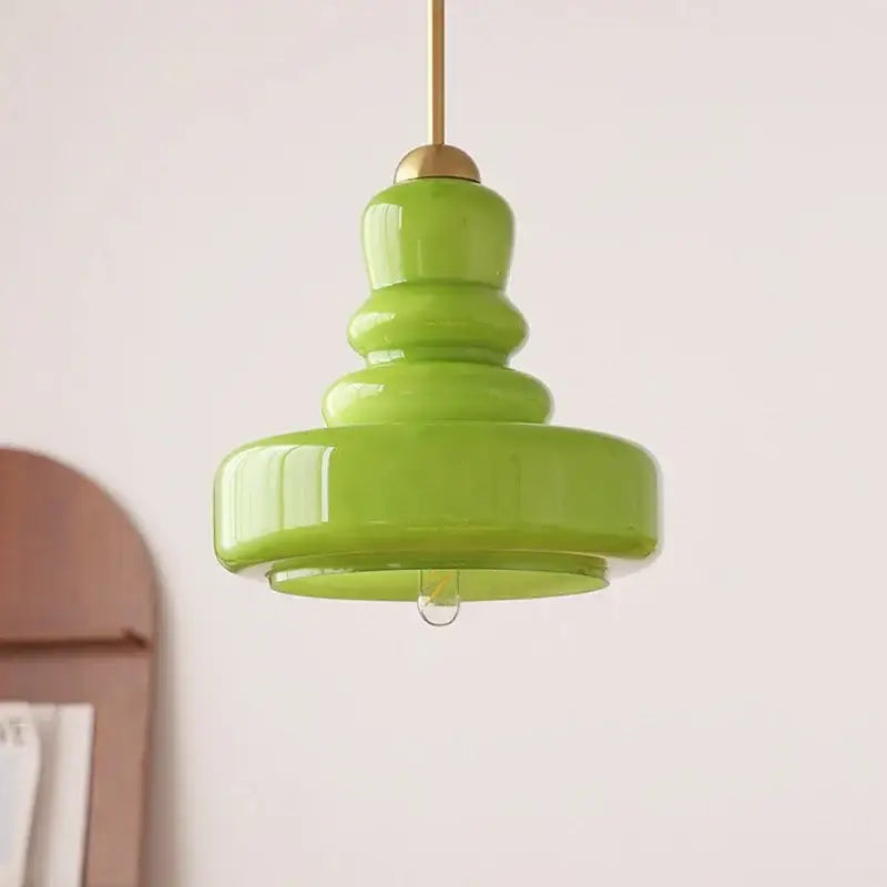 A vibrant lime green tiered glass pendant light with brass accents ideal as pendant lights ceiling for kitchens