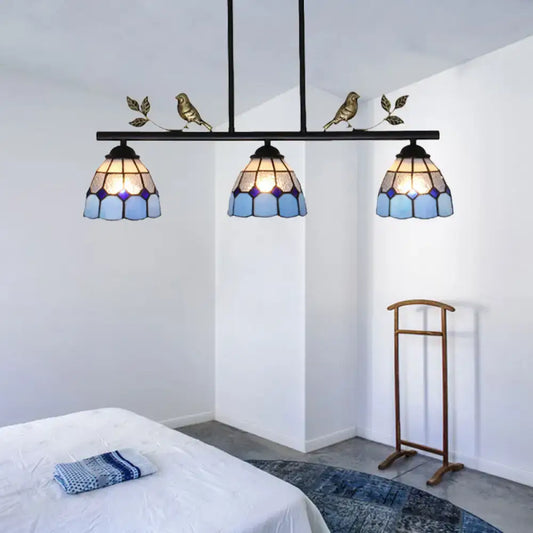 Three-light tiffany-style pendant light fixture with blue stained glass shades and a black metal curved bird shape frame