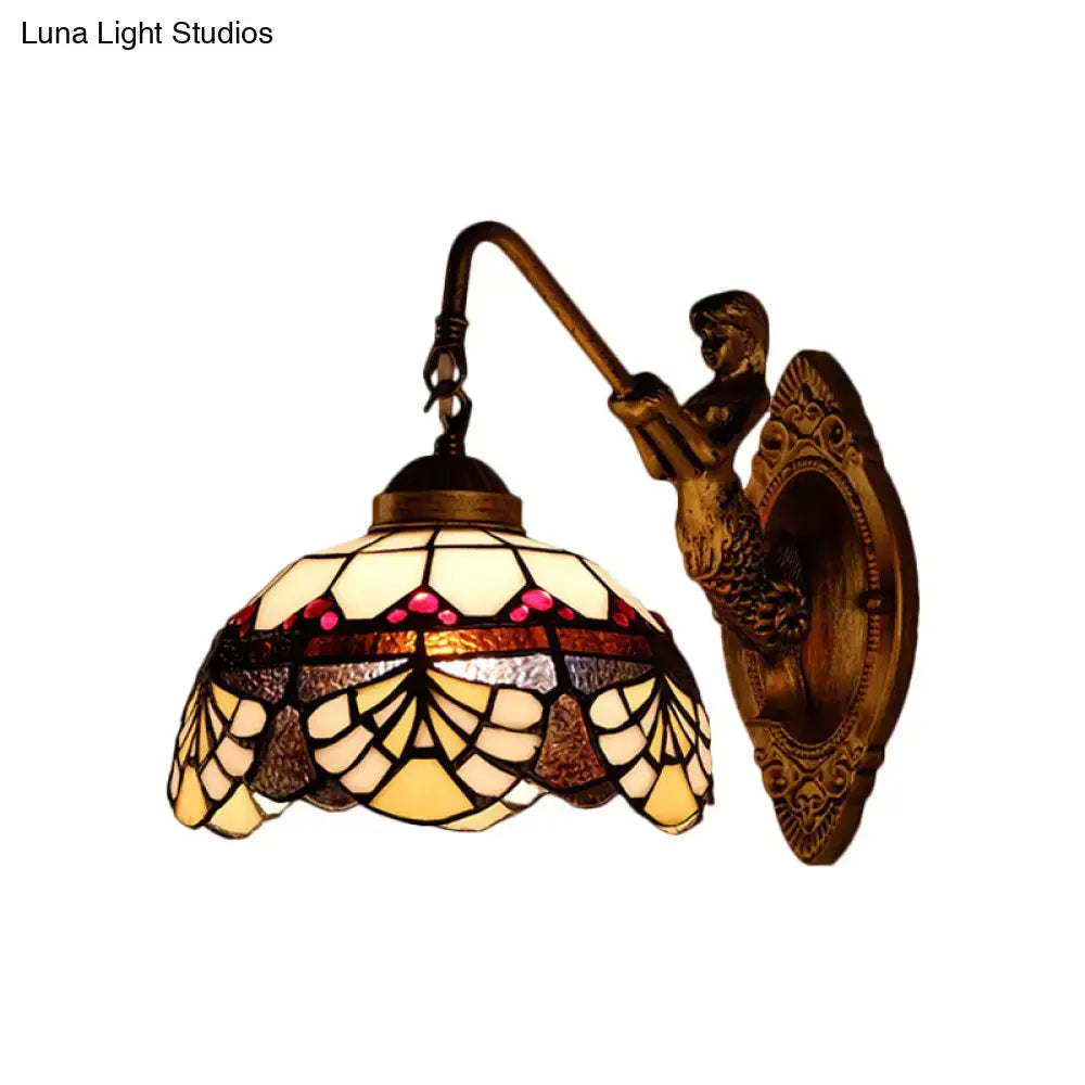 Antique brass mermaid-themed wall sconce with tiffany gold cut glass shade in cream amber and pink hues for bedroom lighting