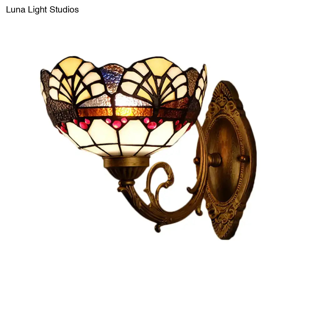 Antique brass-finished wall sconce with tiffany gold cut floral stained gold cut glass shade in cream amber and pink hues