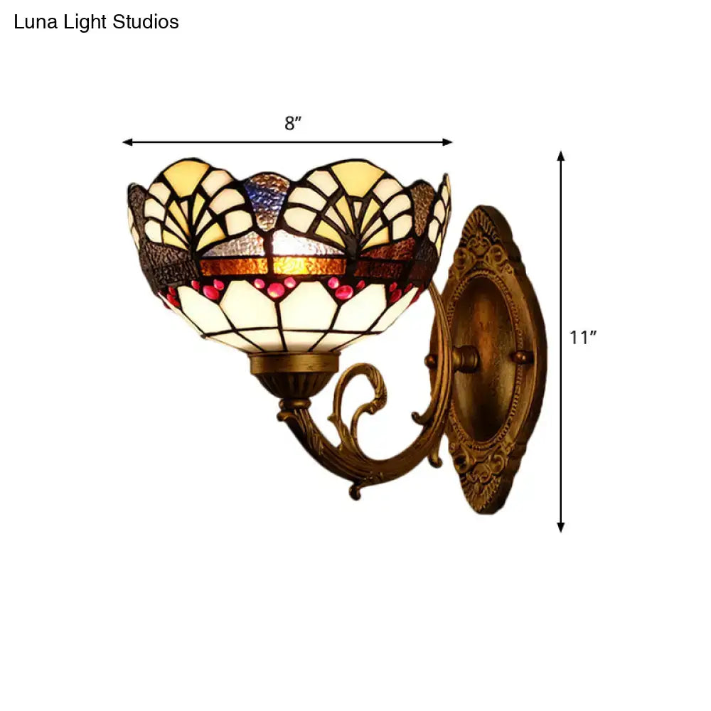 Antique brass-finished bedroom wall sconce with tiffany gold cut floral stained glass shade in cream yellow amber and red hues