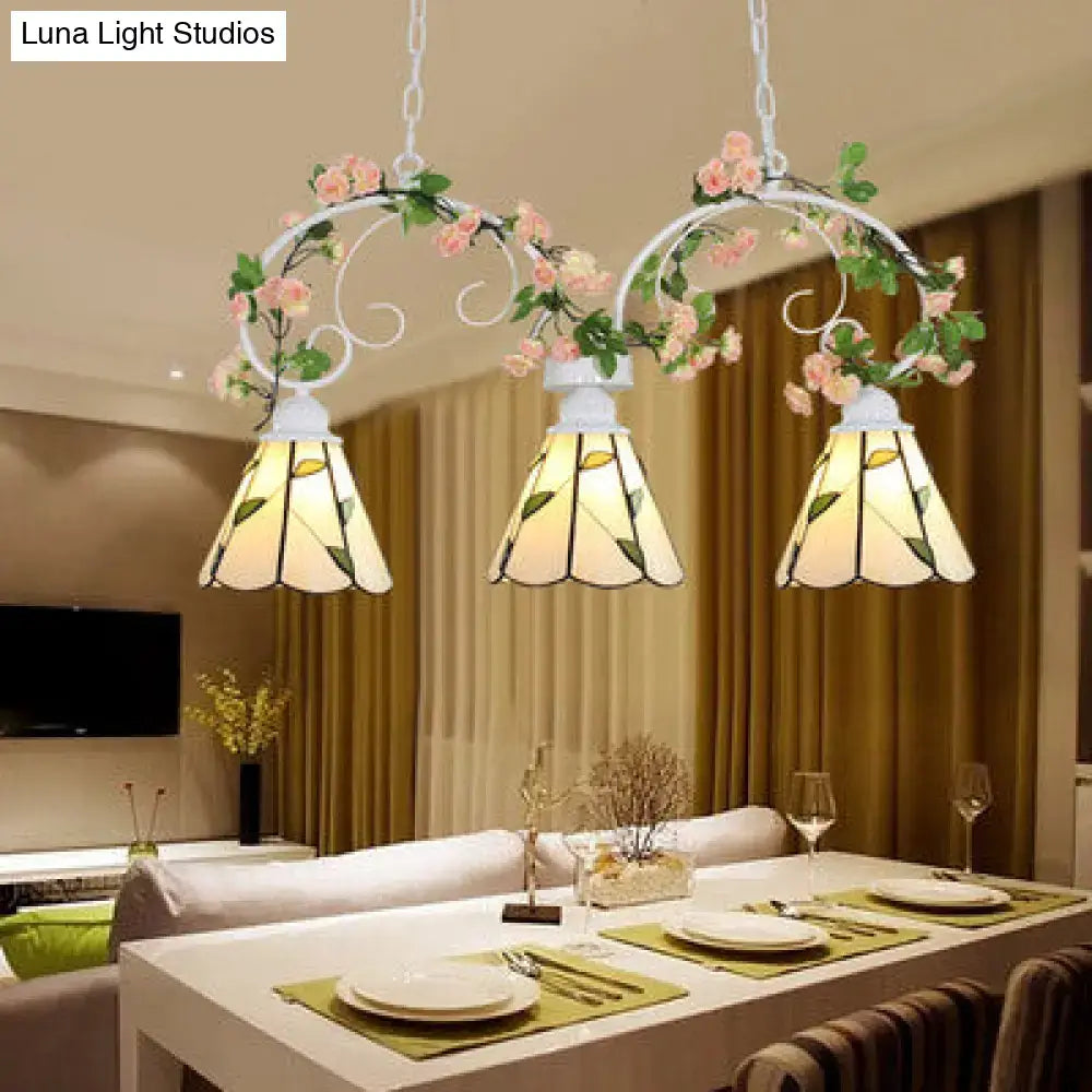 White wrought iron pendant light with leaf pattern and pink stainless glass cone shades featuring floral accents