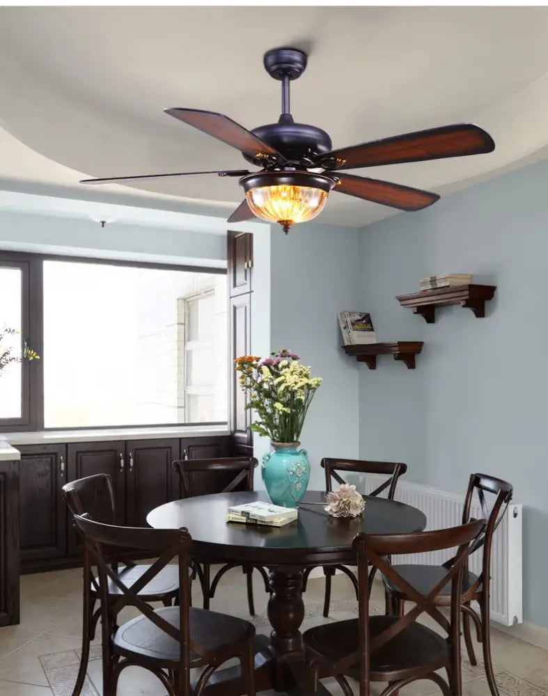 Dark bronze tiffany ceiling fan with five wooden blades and warm-toned glass lamp light for living room use