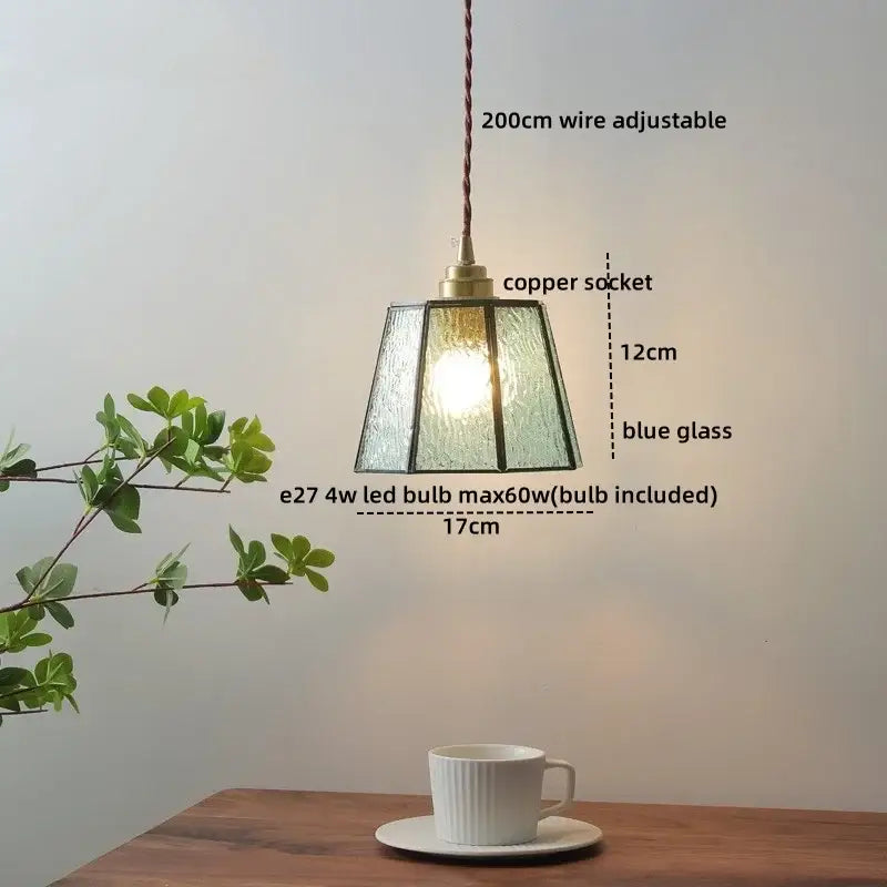 A blue textured glass copper led pendant lamp with a copper socket and braided cord for dining room lighting