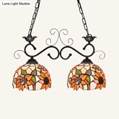 Vibrant sunflower-themed stainless glass pendant light with ornate black wrought iron arms and chains for island lighting