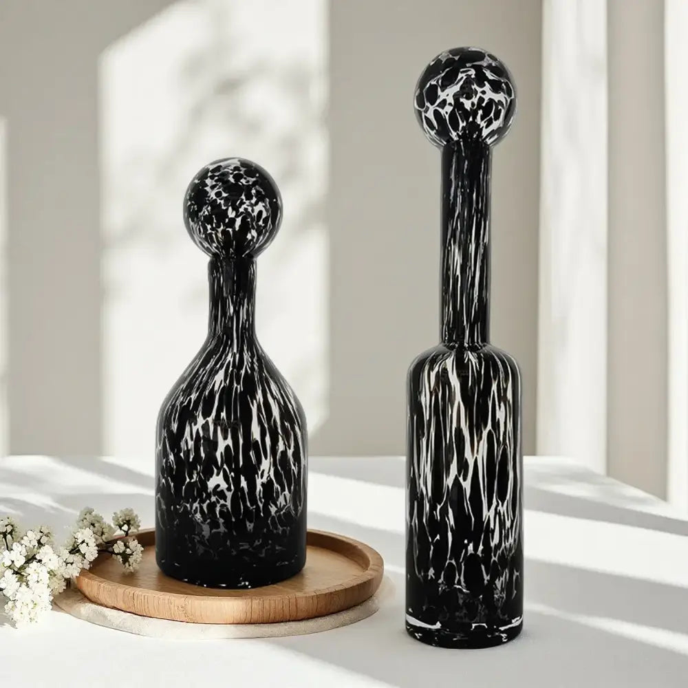 Two black and white marbled glass decanters with spherical tops for decorbites leopard print glass living room decor
