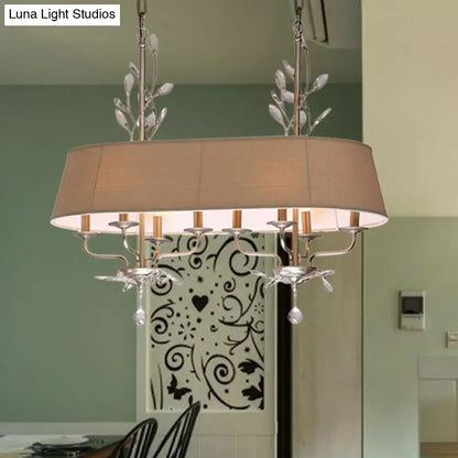 Silver-toned traditional chandelier with beige fabric shade and crystal leaf accents for dining room island lighting