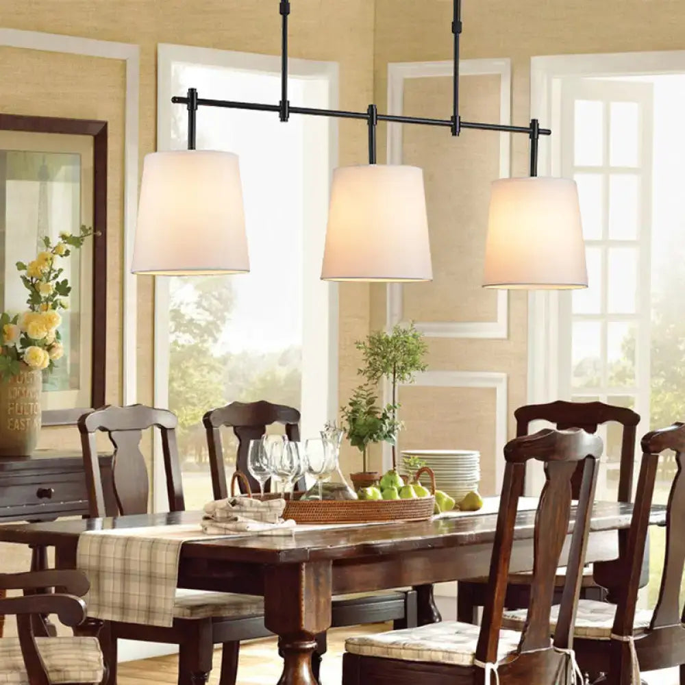 Traditional black metal chandelier with three beige fabric shades for pendant lighting over dining room barrel island lights