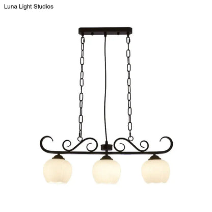 Black wrought iron DecorBites™ traditional island lighting fixture with three milky glass globe shades for dining room