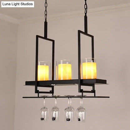 Black metal chandelier with three glowing amber candle lights and metal wine glass rack in traditional black marble finish